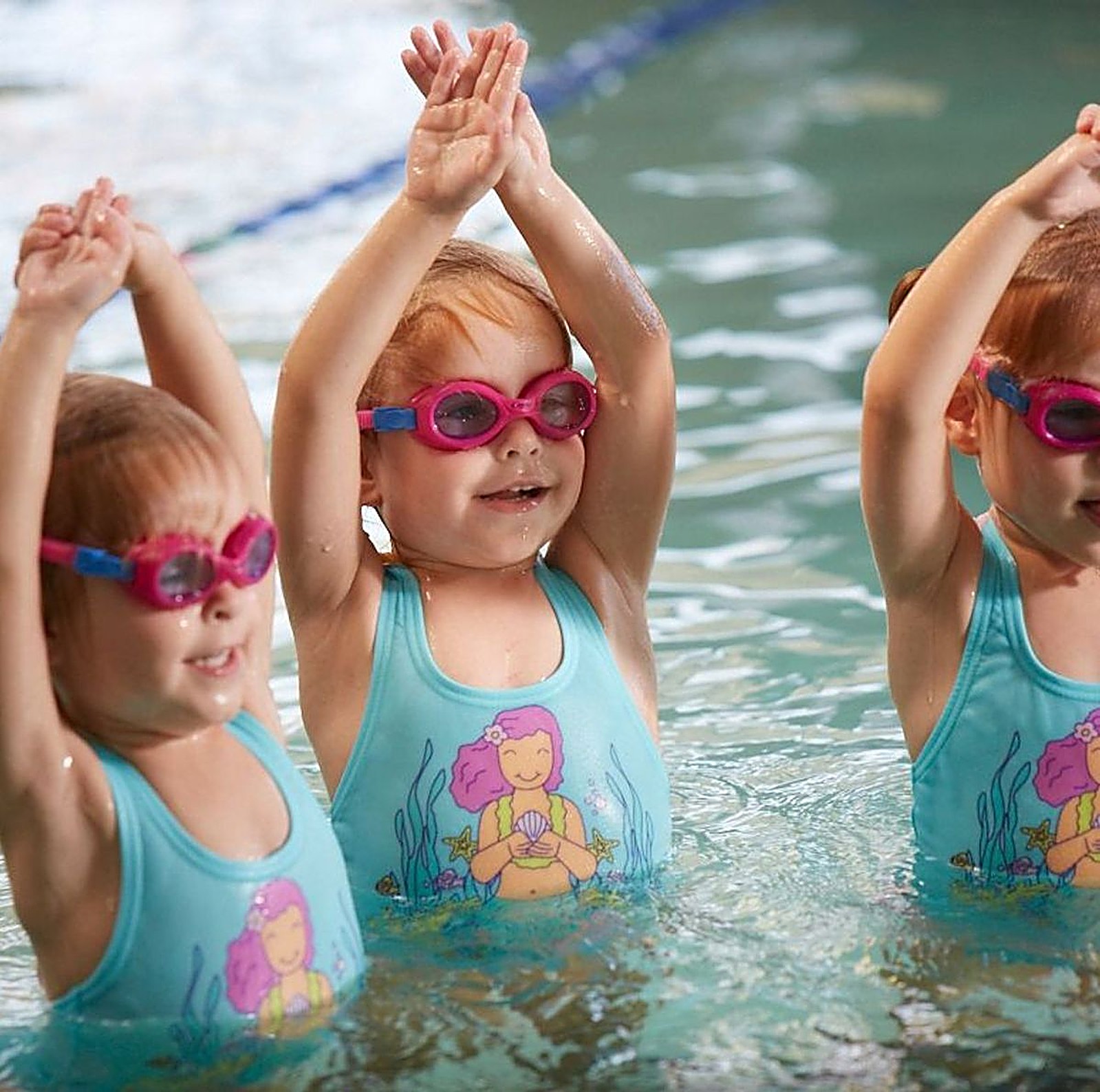 Three girls with arms up in the pool